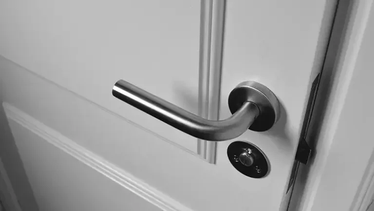 Close-up of a modern silver door handle on a wooden door, perfect for reliable handyman services door repair and installation services in Bellevue, NE.
