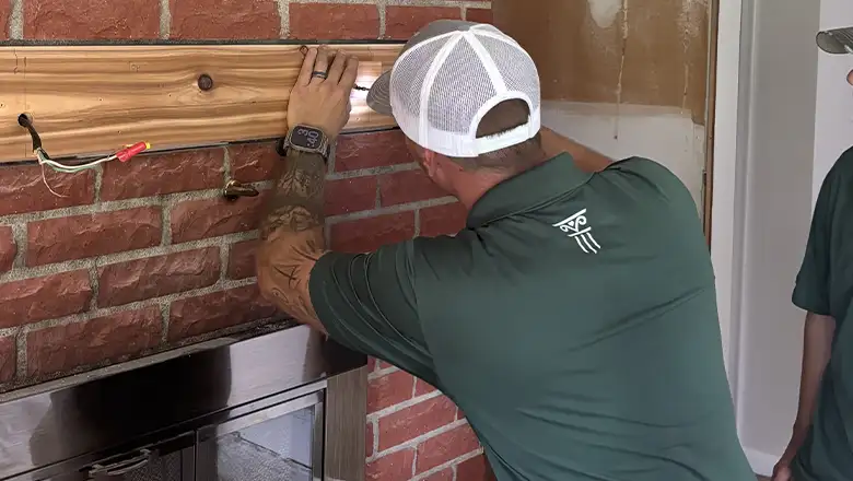 Two of our amazing technicians hanging a shelf above a fireplace
